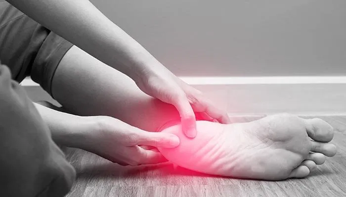 Person holding their painful heel and ankle, highlighting the need for a heel pain specialist in Lakeland Hills Blvd to treat chronic foot pain affecting daily life